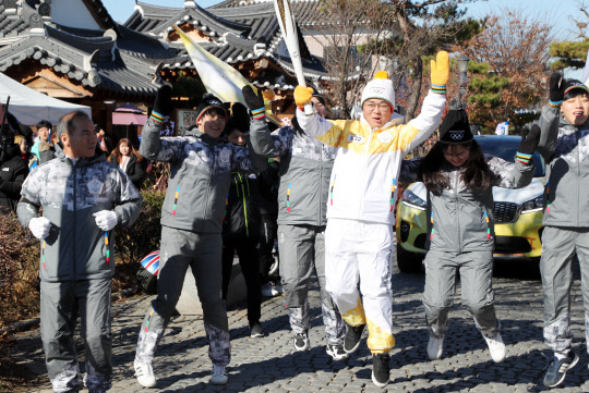 1일 오후 전북 전주한옥마을에서 2018 평창올림픽 성화 봉송 주자가 파이팅을 외치며 바닥에서 뛰어오르고 있다.